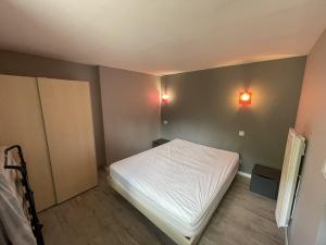 a bedroom with a bed and two lights on the wall at Beau duplex 6 pers. à 200m des pistes, parking gratuit - FR-1-787-11 in Saint-Jacques-des-Blats