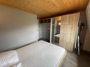 a bedroom with a white bed and a wooden ceiling at Bel appartement duplex proche des pistes avec balcon et parking - FR-1-787-16 in Saint-Jacques-des-Blats +1 photo