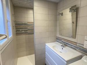 ein weißes Badezimmer mit Waschbecken und Spiegel in der Unterkunft Grand chalet mitoyen dans secteur calme et ensoleillé - FR-1-787-38 in Laveissière