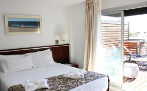 a hotel room with a bed and a balcony at Ribera Sur Hotel Mar del Plata in Mar del Plata