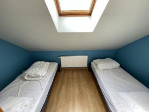 two beds in a room with blue walls and a window at Duplex rénové 2 chambres, proche pistes, navette et gare, avec wifi et équipements complets - FR-1-787-4 in Laveissière