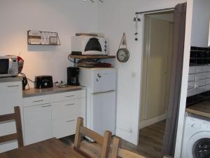 eine Küche mit Kühlschrank und Mikrowelle in der Unterkunft Bel appartement rénové T2 avec balcon au pied des pistes - FR-1-787-10 in Laveissière