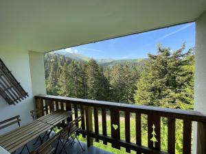 einen Balkon mit einer Bank und Bergblick in der Unterkunft Appartement cosy avec balcon, accès direct piste et parking privatif - FR-1-787-20 in Laveissière