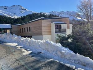 ein Schneehaufen vor einem Gebäude in der Unterkunft Appartement cosy avec balcon, accès direct piste et parking privatif - FR-1-787-20 in Laveissière + 2 Fotos