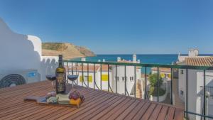 a balcony with a bottle of wine and wine glasses at Vila Luz Mar in Luz