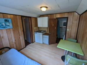Kleines Zimmer mit einer Küche und einem Tisch in der Unterkunft Tiny Wood Cottage 11 in Wasaga Beach