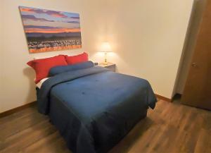 a bedroom with a blue bed and a painting on the wall at A Frame of Mind in Red River