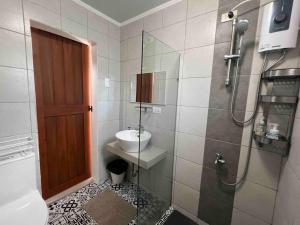 a bathroom with a shower with a toilet and a sink at Romantic Cabin Retreat with Garden View and Free Parking in Amadeo +9 photos