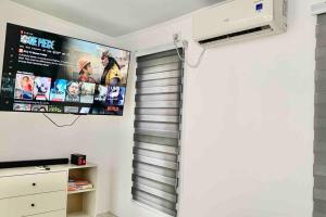 a room with a television and a wall mounted screen at Romantic Cabin Retreat with Garden View and Free Parking in Amadeo