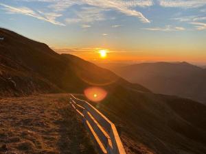 eine Straße, die zum Sonnenuntergang auf einem Berg führt in der Unterkunft Studio rénové avec balcon, au pied des pistes, accès WIFI - FR-1-787-53 in Laveissière + 1 Foto