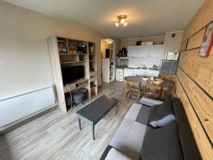 ein Wohnzimmer mit Sofa und Tisch in der Unterkunft Appartement T2 cabine avec balcon, accès piste, parking, animaux bienvenus - FR-1-787-69 in Laveissière