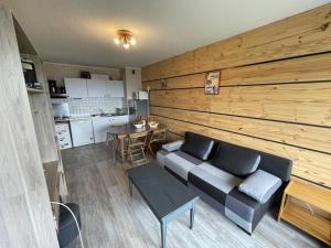 ein Wohnzimmer mit Sofa und Tisch in der Unterkunft Appartement T2 cabine avec balcon, accès piste, parking, animaux bienvenus - FR-1-787-69 in Laveissière