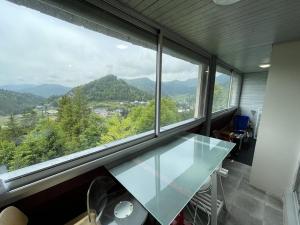 ein Glastisch in einem Raum mit einem großen Fenster in der Unterkunft Appartement T2 cabine avec balcon, accès piste, parking, animaux bienvenus - FR-1-787-69 in Laveissière + 2 Fotos