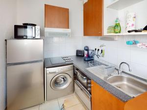 una piccola cucina con frigorifero e lavandino di Appartement de charme avec piscine, terrasse, parking, clim et Wi-Fi – à 10 min des plages - FR-1-785-2 a Frontignan Altre 2 foto