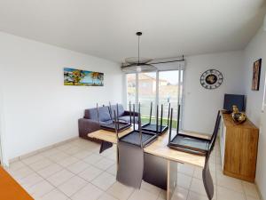 un soggiorno con un tavolo e un divano di Appartement de charme avec piscine, terrasse, parking, clim et Wi-Fi – à 10 min des plages - FR-1-785-2 a Frontignan
