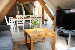 una sala de estar con una mesa con un jarrón de flores en Välkommen, en Stralsund