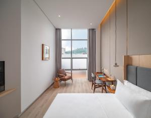 Un ou plusieurs lits dans un hébergement de l'établissement Wuyu Hotel - Chongqing Liangjiang Happiness Plaza & Xingfu Square & GuangdianYuan metro