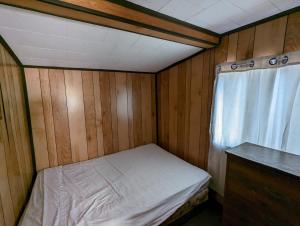 una piccola stanza con un letto e una finestra di Tiny Wood Cottage 15 a Wasaga Beach