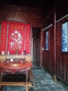 Huangtuhe窑屋民宿的一间设有桌子和红色墙壁的房间