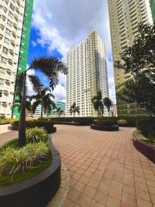 a courtyard with palm trees and tall buildings at Avida Riala Studio condo unit T2 in Cebu City