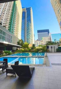 a swimming pool in a city with tall buildings at Avida Riala Studio condo unit T2 in Cebu City