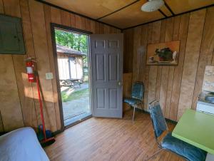 una stanza con una porta, un tavolo e delle sedie di Tiny Wood Cottage 18 a Wasaga Beach