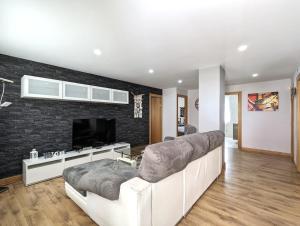 ein Wohnzimmer mit Sofa und Fernseher in der Unterkunft Casa moderno en Renedo de Pielagos in Renedo de Piélagos