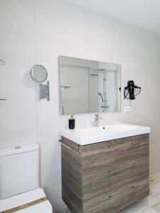 ein Badezimmer mit Waschbecken, Spiegel und Toilette in der Unterkunft Casa moderno en Renedo de Pielagos in Renedo de Piélagos + 10 Fotos