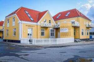 a row of yellow houses with red roofs at Skagen Havn Lejligheder in Skagen