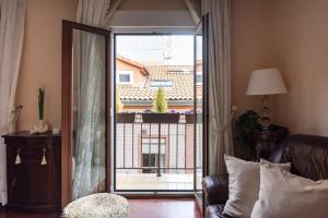 een woonkamer met een glazen schuifdeur naar een balkon bij Apartamento en el centro in Santander