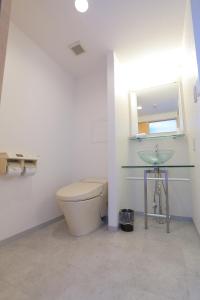 a bathroom with a toilet and a glass sink at RE Hotel 谷町9丁目 in Osaka