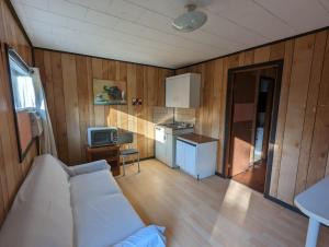 un soggiorno con divano e cucina di Tiny Wood Cottage 20 a Wasaga Beach