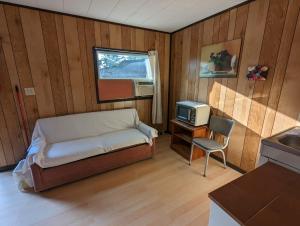 una camera da letto con un letto e una TV di Tiny Wood Cottage 20 a Wasaga Beach