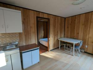 una piccola cucina con tavolo e letto di Tiny Wood Cottage 20 a Wasaga Beach
