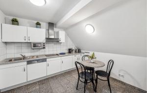 a kitchen with white cabinets and a table and chairs at Lovely Apartment In Kühlungsborn in Kühlungsborn