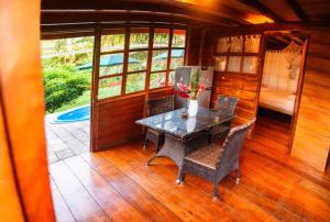 a dining room with a table and chairs and a refrigerator at CHOMI HOUSE TAMBOPATA in Puerto Maldonado