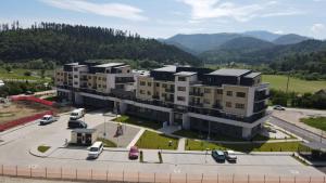 an apartment building with cars parked in a parking lot at Anto Apartments in Râşnov