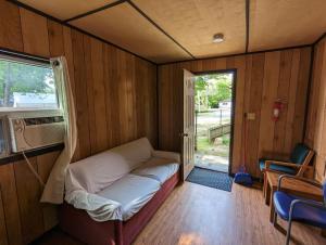 una piccola stanza con un letto e una finestra di Tiny Wood Cottage 21 a Wasaga Beach
