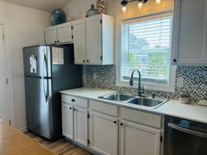 霍尔顿海滩Blue Crab Cottage home的配有白色橱柜和不锈钢冰箱的厨房
