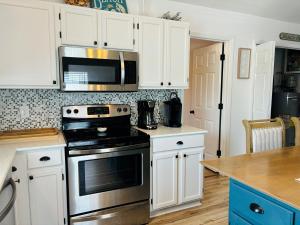 霍尔顿海滩Blue Crab Cottage home的厨房配有白色橱柜和炉灶烤箱