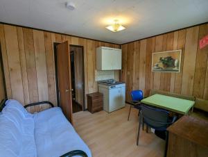 una camera con letto e tavolo e una cucina di Tiny Wood Cottage 22 a Wasaga Beach