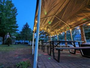 un gruppo di tavoli da picnic sotto una tenda di Tiny Wood Cottage 22 a Wasaga Beach