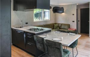 a kitchen with a stove and a table with chairs at 3 Bedroom Pet Friendly Home In Epe in Epe