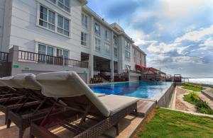 a hotel with a swimming pool next to a building at Hotel on The Rock in Kupang