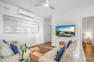 Port AdelaideBeach Stayz Semaphore Three Bedroom Apartment的客厅配有白色家具和墙上的大画作