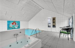 ein Badezimmer mit einer Badewanne und einem Tisch und einem Tisch in der Unterkunft Cozy Home In Væggerløse With Sauna in Bøtø By