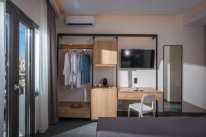a bedroom with a desk and a tv in a room at King's Blue , Superior Living in Heraklio Town
