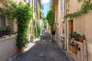 a person walking down an alley between two buildings at Charmant Duplex centre de nimes in Nîmes