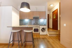 a kitchen with a counter and stools in a room at PORTAL DEL ANGEL Barcelonastuff Apartments in Barcelona