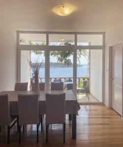 a dining room with a table and a view of the ocean at Prizba Tomas One in Blato
